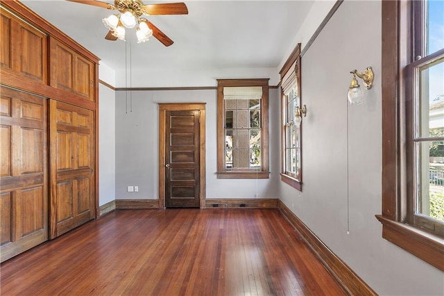 interior space featuring dark wood-type flooring and ceiling fan