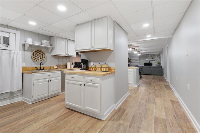 kitchen featuring light hardwood / wood-style floors, sink, wooden counters, and white cabinets