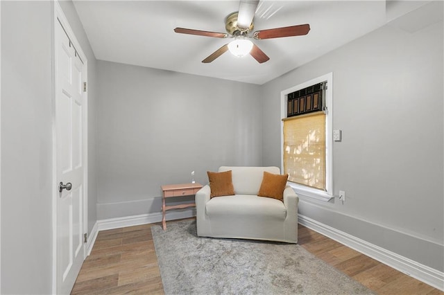 living area with ceiling fan and hardwood / wood-style floors