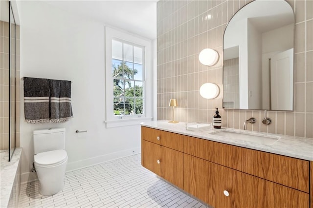 full bathroom featuring baseboards, toilet, tile walls, tile patterned floors, and vanity