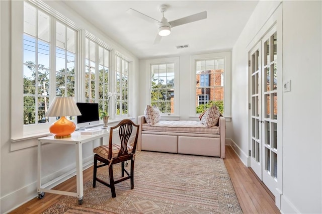 office space with baseboards, visible vents, a ceiling fan, and light wood-type flooring