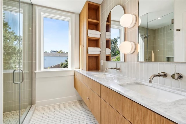 full bath featuring a stall shower, a wealth of natural light, tile patterned flooring, and a sink