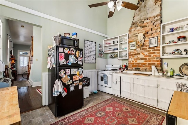 kitchen with white cabinetry, gas range gas stove, ceiling fan, dark wood-type flooring, and black fridge