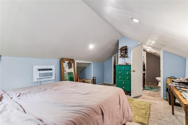 carpeted bedroom featuring connected bathroom, a wall mounted AC, and lofted ceiling