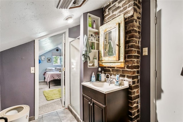 bathroom featuring vanity, vaulted ceiling, tile patterned flooring, a textured ceiling, and an enclosed shower