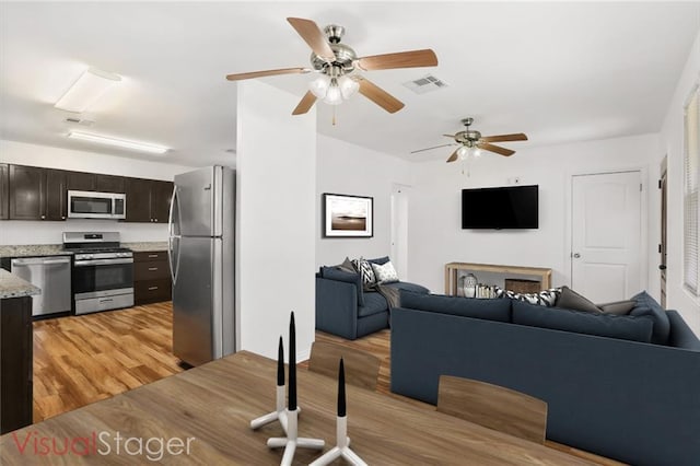 living room with ceiling fan and light wood-type flooring