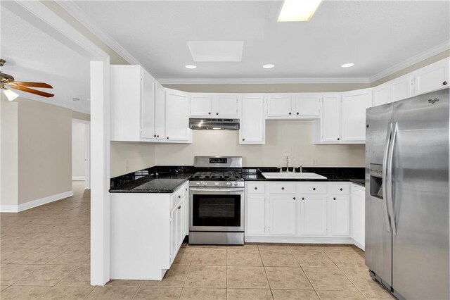 kitchen with appliances with stainless steel finishes, dark stone counters, sink, and light tile patterned flooring