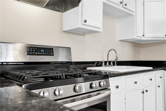 kitchen featuring stainless steel gas range, white cabinetry, sink, and exhaust hood