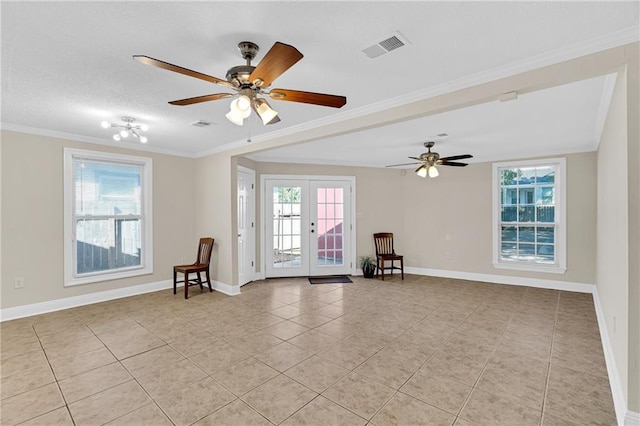 tiled empty room with ceiling fan, a textured ceiling, french doors, and ornamental molding