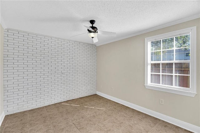 empty room featuring ceiling fan, a textured ceiling, crown molding, and brick wall