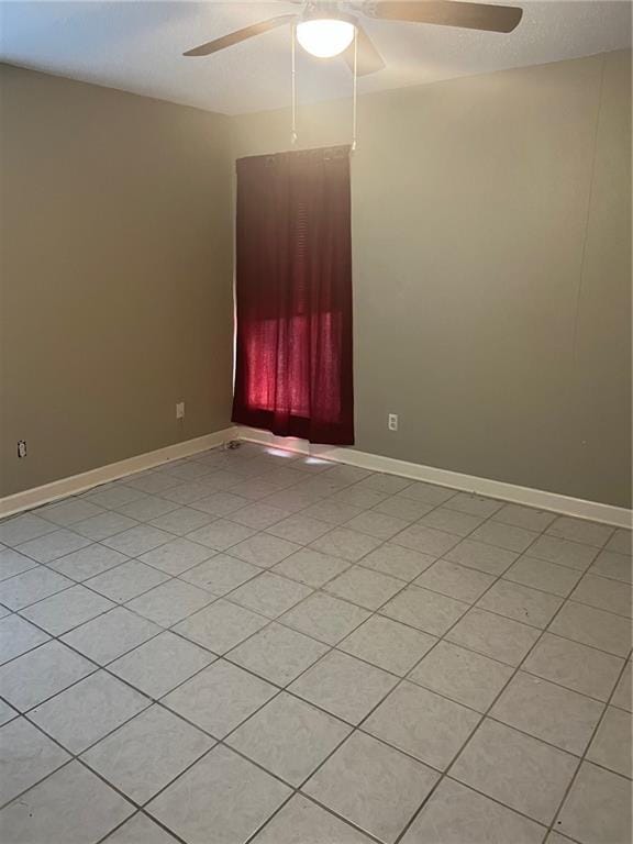 tiled spare room with ceiling fan