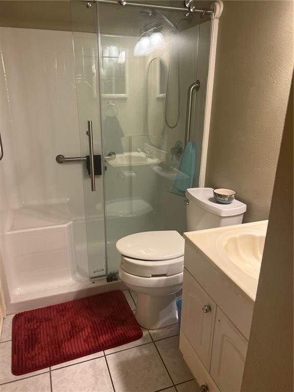 bathroom with toilet, walk in shower, vanity, and tile patterned flooring