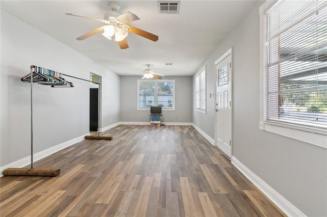 unfurnished living room with dark hardwood / wood-style floors and ceiling fan