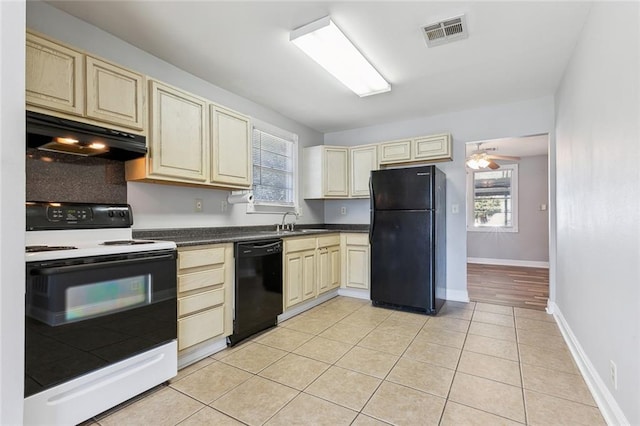 kitchen featuring sink, black appliances, light tile patterned floors, and cream cabinets