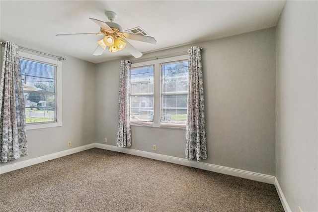 spare room featuring a wealth of natural light, carpet floors, and ceiling fan