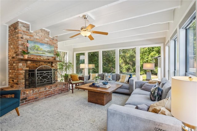 sunroom featuring a brick fireplace, a wealth of natural light, ceiling fan, and beam ceiling