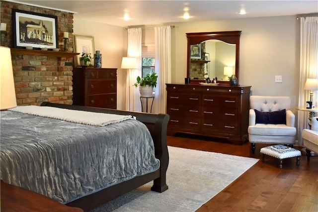 bedroom with dark hardwood / wood-style flooring and a fireplace