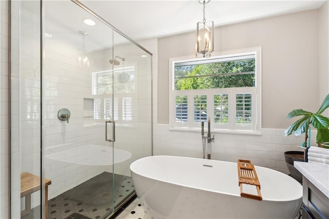 bathroom featuring vanity, plus walk in shower, tile walls, and tile patterned floors