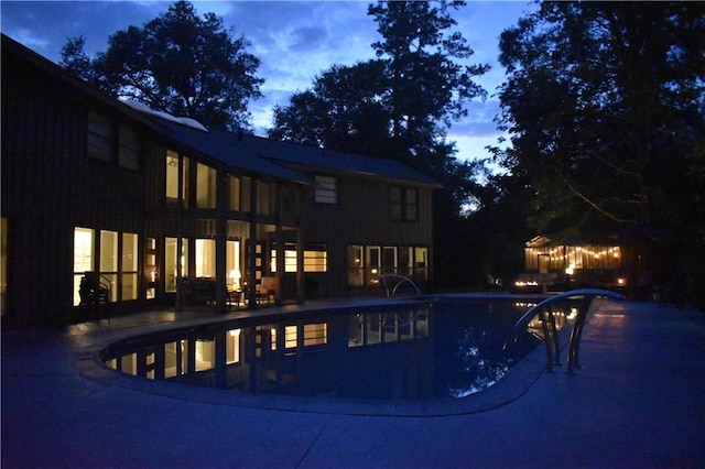 pool at dusk with a patio