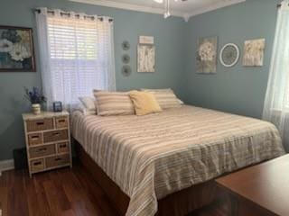 bedroom with ornamental molding and dark hardwood / wood-style flooring