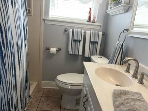 bathroom featuring toilet, vanity, tile patterned floors, and a shower with shower curtain