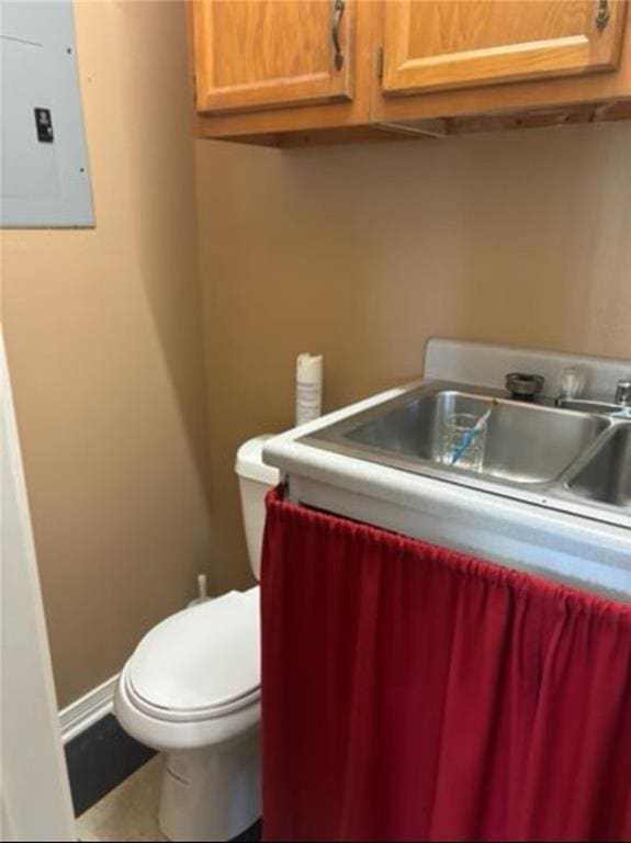 bathroom with toilet and electric panel