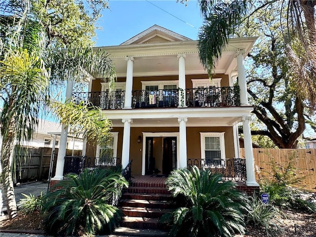 back of house featuring a balcony and a porch