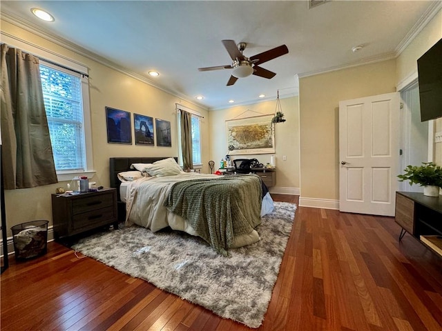 bedroom featuring dark hardwood / wood-style flooring, crown molding, baseboard heating, and ceiling fan