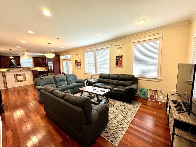 living room with dark wood-type flooring and crown molding