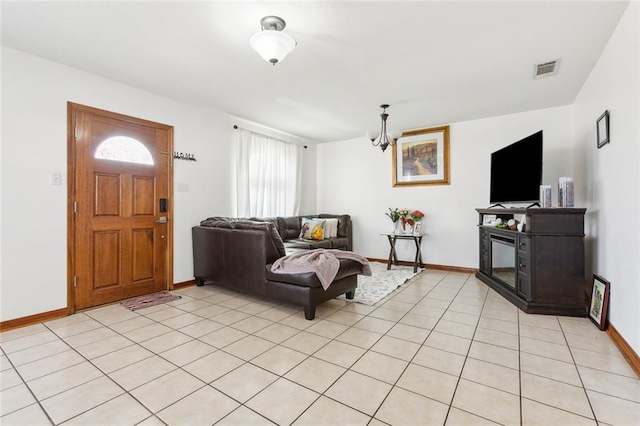 tiled living room with a notable chandelier