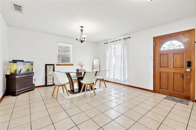 dining space with light tile patterned flooring, an inviting chandelier, and plenty of natural light