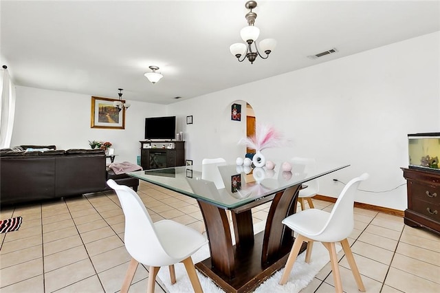 dining space featuring a chandelier, a fireplace, and light tile patterned floors