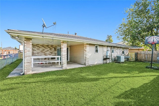 rear view of property featuring a patio area, central AC, and a yard