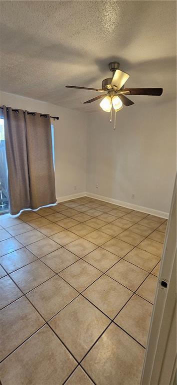 4218 Hessmer Ave Unit 112, Metairie, LA 70002 - spare room featuring light tile patterned floors, a textured ceiling, and ceiling fan
