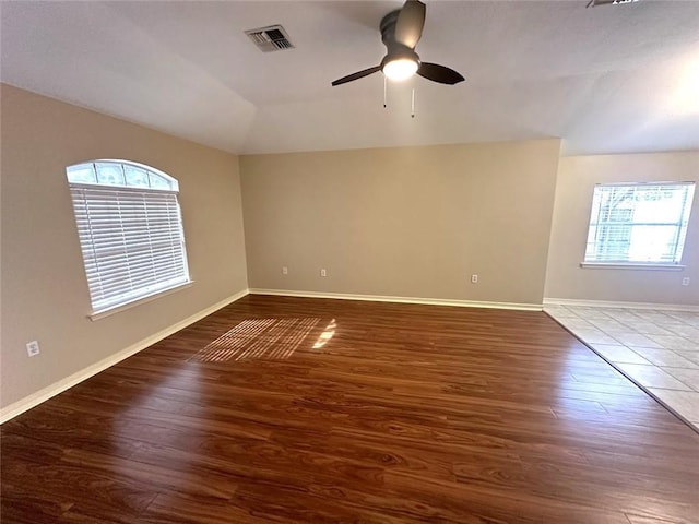 unfurnished room featuring vaulted ceiling, ceiling fan, and dark hardwood / wood-style flooring