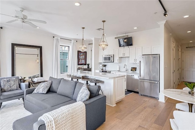 kitchen featuring pendant lighting, white cabinets, stainless steel appliances, and a kitchen island