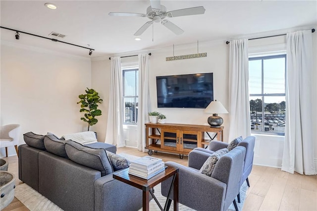 living room with rail lighting, light hardwood / wood-style floors, ornamental molding, and ceiling fan