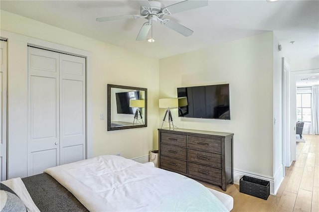 bedroom with a closet, light wood-type flooring, and ceiling fan