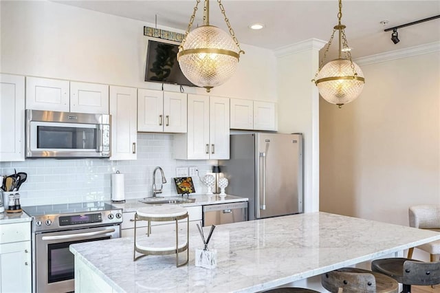 kitchen with sink, white cabinetry, hanging light fixtures, and stainless steel appliances