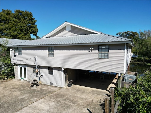 20442 Johnson Dr, Springfield, LA 70462 - exterior space with an attached garage, concrete driveway, french doors, and metal roof