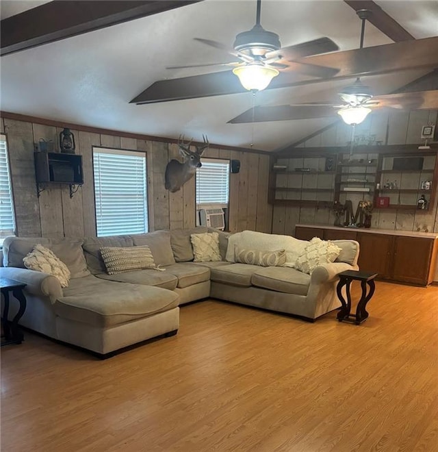 20442 Johnson Dr, Springfield, LA 70462 - living area featuring lofted ceiling, ceiling fan, wooden walls, cooling unit, and light wood finished floors