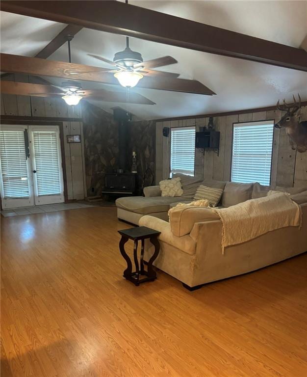 living room with light hardwood / wood-style flooring, lofted ceiling with beams, and ceiling fan