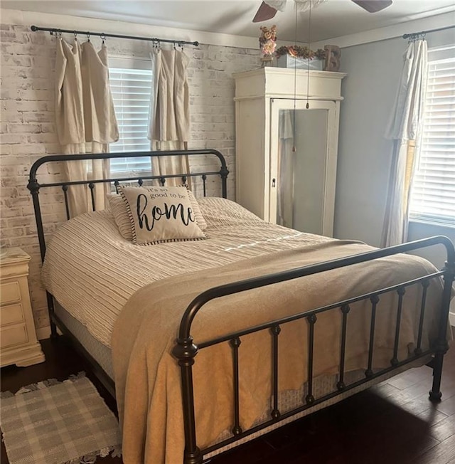 20442 Johnson Dr, Springfield, LA 70462 - bedroom with brick wall, ceiling fan, and wood finished floors
