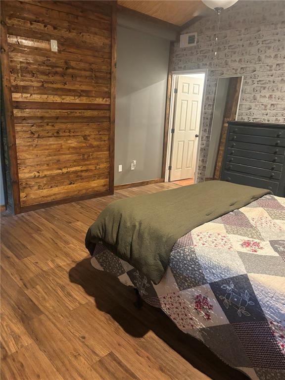 20442 Johnson Dr, Springfield, LA 70462 - bedroom featuring baseboards, visible vents, wood finished floors, and lofted ceiling