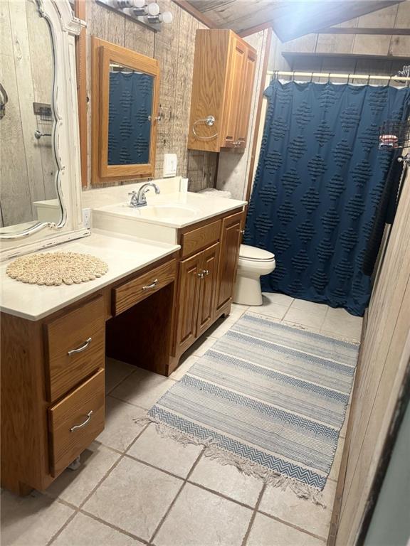 20442 Johnson Dr, Springfield, LA 70462 - full bathroom featuring tile patterned flooring, wood walls, vanity, toilet, and a shower with curtain