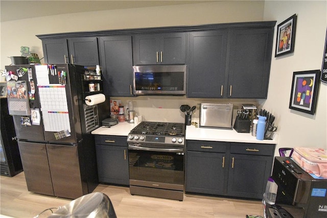 kitchen with appliances with stainless steel finishes and light hardwood / wood-style flooring