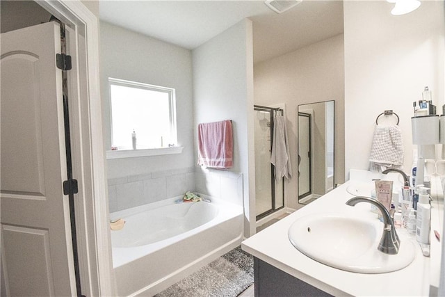 bathroom featuring vanity and independent shower and bath