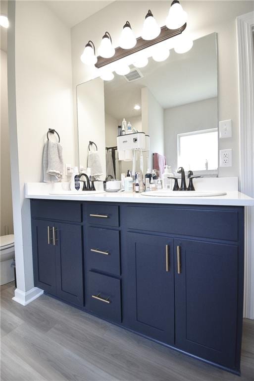 bathroom featuring toilet, hardwood / wood-style floors, and vanity