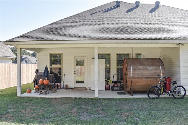 back of property featuring a patio area and a lawn