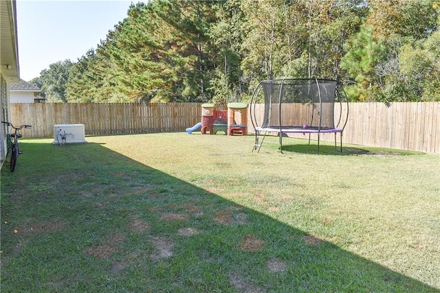 view of yard with a playground and a trampoline